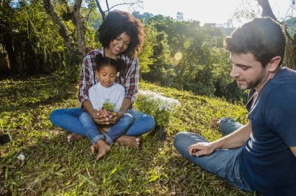 parents-with-daughter-sitting-hill